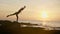 Silhouette yoga practice at sunset. Yong woman doing yoga exercise on the beach