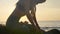 Silhouette yoga practice at sunset. Yong woman doing yoga exercise on the beach