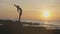 Silhouette yoga practice at sunset. Yong woman doing yoga exercise on the beach