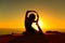 Silhouette of a yogi doing yoga advanced exercise at sunset