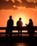 Silhouette of young adults on a fishing pier watching the sunset. Hanging out with friends, enjoying nature. Long Island NY
