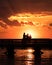 Silhouette of young adults on a fishing pier watching the sunset. Hanging out with friends, enjoying nature. Long Island NY