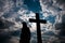 Silhouette of a young boy and a catholic cross at sundown