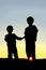 Silhouette Young Children Holding Hands at Sunset