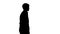 Silhouette Young confident businessman walking with his hands in his pockets.