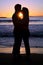 Silhouette of a young couple kissing at the beach