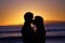 Silhouette of a young couple kissing at the beach