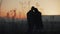 Silhouette of young couple in love enjoying a sunset over the mountains. Vacation, travel, romance, marriage proposal