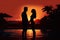 Silhouette of a young couple standing near swimming pool at sunset, Silhouette of man and woman standing in swimming pool at