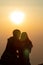 Silhouette of a young couple watching the sunset during twilight on a high mountain and embracing happily. Happy couple embracing