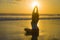 Silhouette of young fit and attractive sport woman in beach sunset yoga practice workout sitting on wet sun in front of sea in med