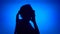 Silhouette of young frustrated woman. Female`s face in profile in despair on blue background