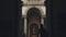 Silhouette of young girl with backpack walking through archway to statues of Cathedral. Pretty woman getting learning and