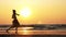 Silhouette of young girl dancing at sunset in slow motion