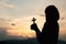 Silhouette of a young girl holding a crucifix to God Morning with beautiful sunrise, Symbol of Faith. Christian life prayer crisis
