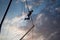 Silhouette of a young girl jumping on a bungee on a trampoline on a sunset background on a sea