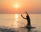 Silhouette of young girl jumping in sea