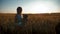 Silhouette young girl playing with teddy bear in a wheat field at sunset. Concept big dream.