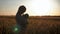 Silhouette young girl playing with teddy bear in a wheat field at sunset. Concept big dream.