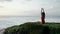 Silhouette of young girl relaxing on the hill in front of sunrise. Woman in red swimsuit doing yoga on Bali. Brunnete