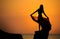 A silhouette of a young girl on rock at sunset 1