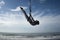 Silhouette of young happy and athletic Asian Indonesian woman doing aero yoga workout training body balance hanging from swing