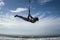 Silhouette of young happy and athletic Asian Indonesian woman doing aero yoga workout training body balance hanging from swing