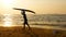 Silhouette of young happy surf man running with long surf boards at sunset on tropical beach. surfer on the beach in sea shore