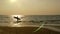 Silhouette of young happy surf man running with long surf boards at sunset on tropical beach. surfer on the beach in sea shore