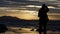 Silhouette of a young lady against the sea during sunset