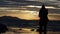 Silhouette of a young lady against the sea during sunset