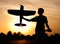 Silhouette of a young man with a model rc airplane