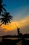 Silhouette of a young man rowing a small boat during a scenic sunset, vertical shot