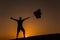 Silhouette of a young man at sunset holding balloons