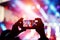 Silhouette of young man, taking photo rock concert on the mobile phone