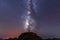 Silhouette of a young man under the stars looking at the lactea way