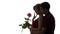 Silhouette of a young man and woman in love on white isolated background, boy came up behind to girl to make a surprise with rose