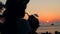 Silhouette of Young Mixed Race Hipster Girl Drinking Fresh Thai Coconut Water Coctail on the Beach Against Beautiful