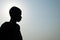 Silhouette of a young monk against the sky.