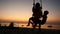 Silhouette of young mother swinging little children in beach swing at sunset beach. slow motion. 1920x1080