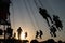 Silhouette of young people on Ferris wheel and swinging carousel in stop motion on sunset background