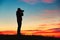 Silhouette of young photographer is enjoying sun. Photographer at the sunrise