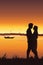 Silhouette of young romantic couple on sunset background