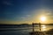 Silhouette of young take photo on sunrise beach.