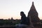 Silhouette of young travel man watching sunrise in temple pagoda area.