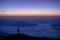 Silhouette of young traveler and backpacker watched the star and milky way and foggy landscape at the morning alone on top of the