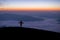 Silhouette of young traveler standing alone on top of the mountain and watched beautiful view of foggy landscape and sunrise in