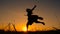 Silhouette of young witch jumping on the broomstick
