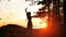Silhouette of young woman dancing in sunset