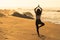 Silhouette of young woman doing greeting the sun yoga asana on the beach